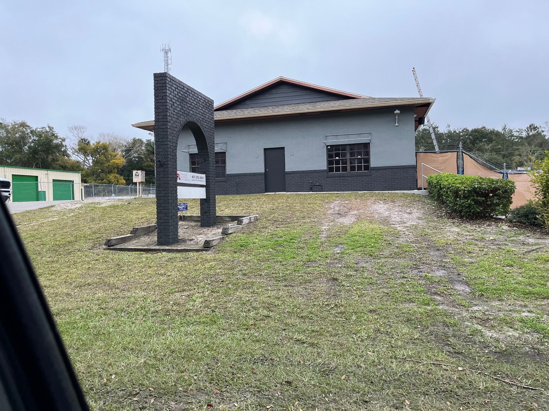 A small house is sitting in the middle of a grassy field.