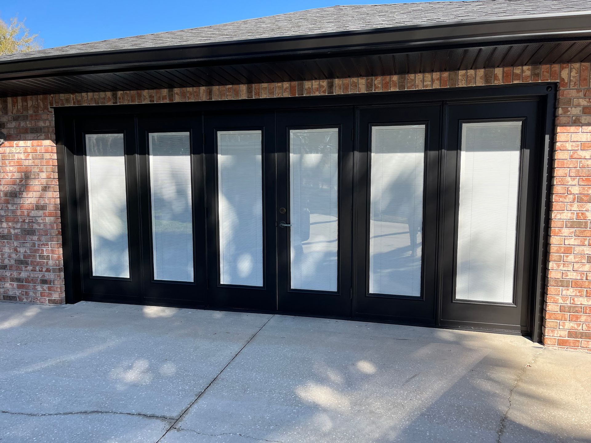 A brick building with a black garage door with a lot of windows