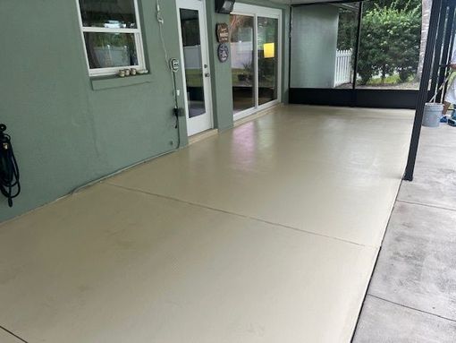 A patio with a screened in porch and a sliding glass door.