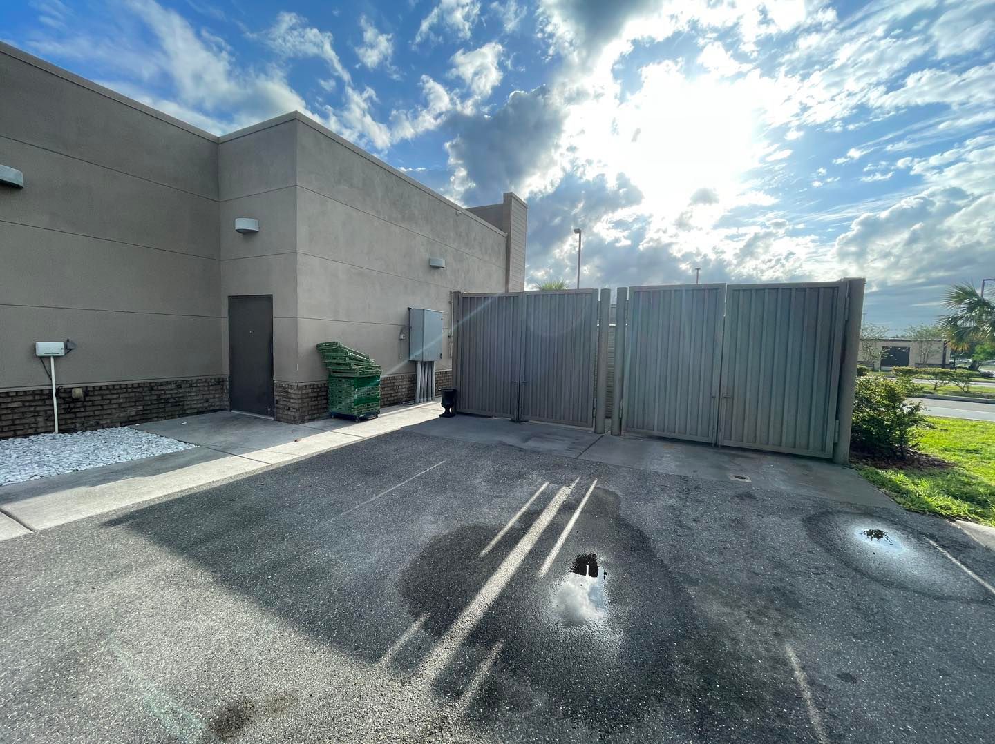 A building with a fence in front of it and a parking lot in front of it.