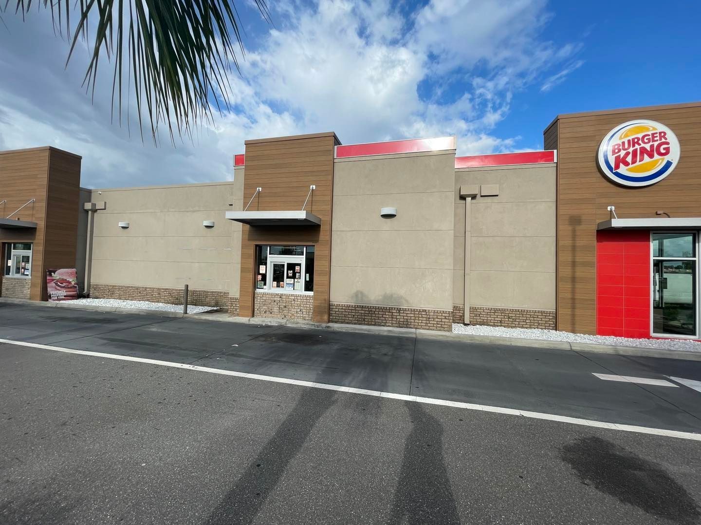 A burger king restaurant with a palm tree in the background