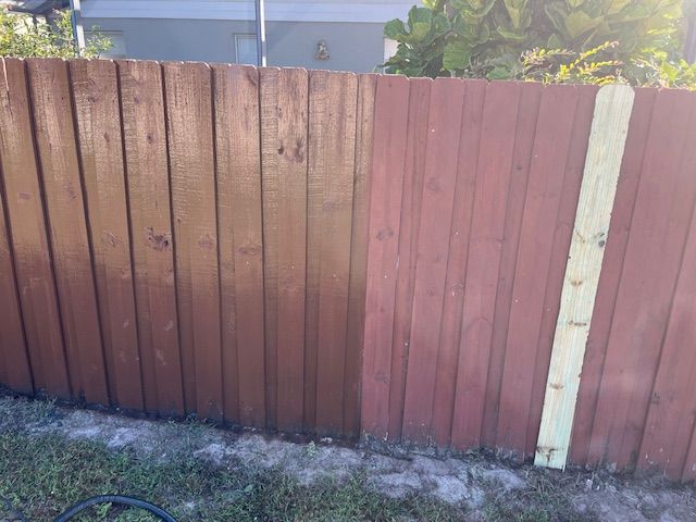 Wooden fence, stained in shades of brown, showing contrast between treated and untreated sections.