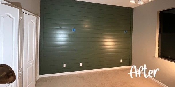 A small house is sitting in the middle of a grassy field.