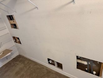 A living room with a ceiling fan and a doorway leading to a bathroom.