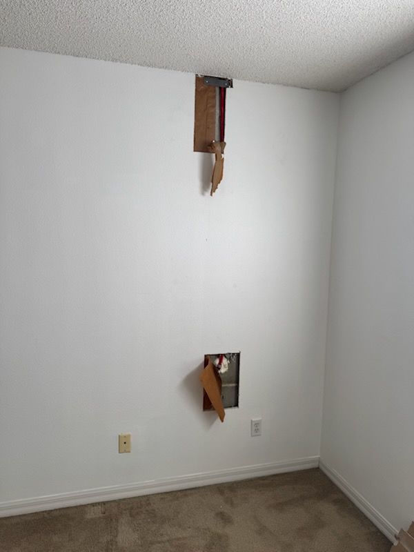 A ladder is sitting on the side of a house next to a sliding glass door.