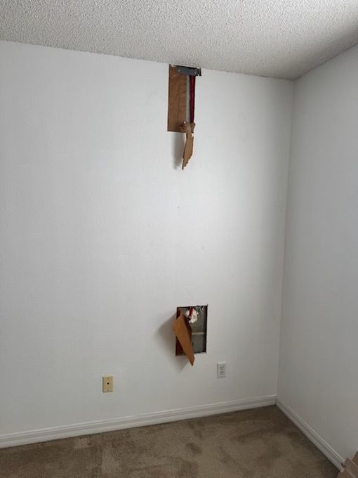 A ladder is sitting on the side of a house next to a sliding glass door.