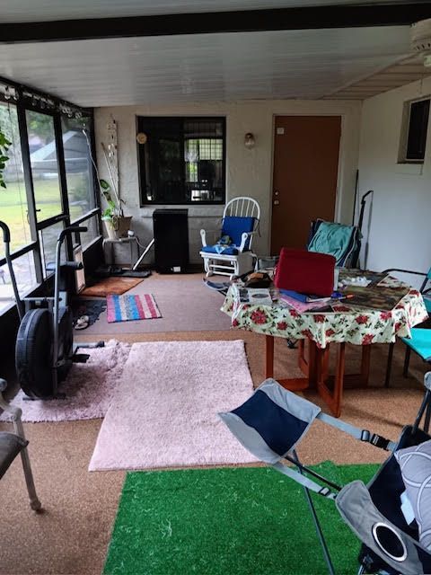 A living room with a couch and a television before being painted.