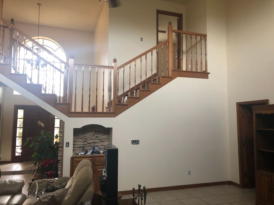 A living room with stairs leading up to the second floor