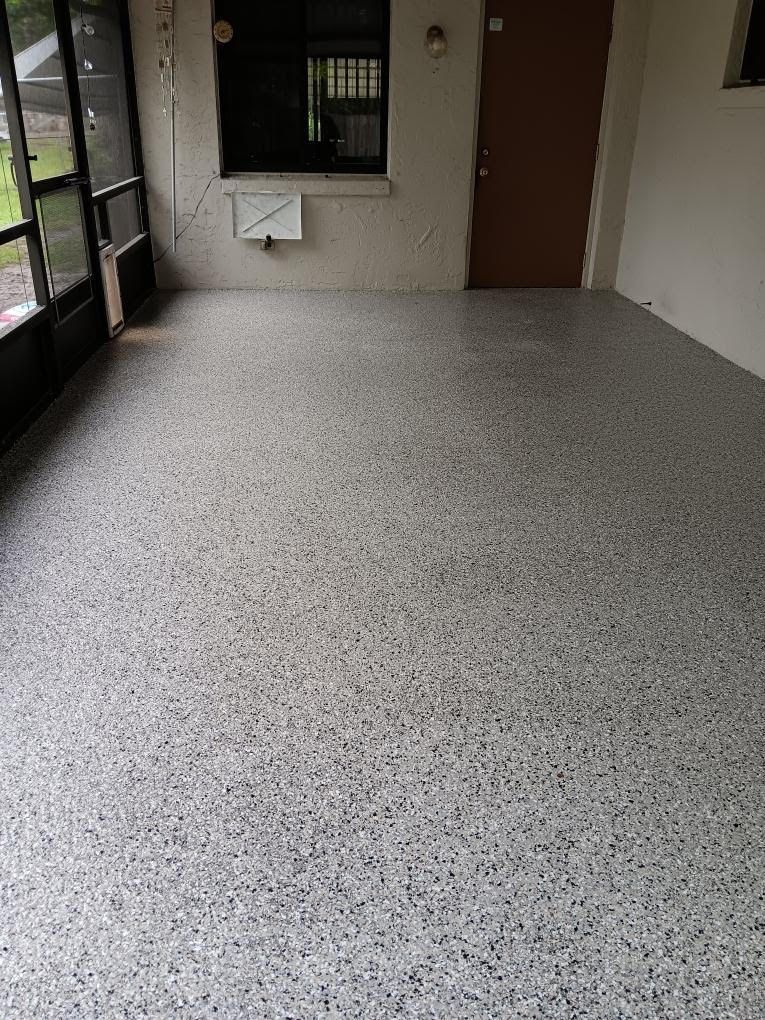 A man is standing on a concrete floor in a garage.