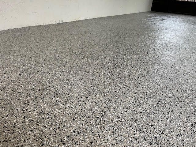 A black and white photo of a carpeted floor in a room.