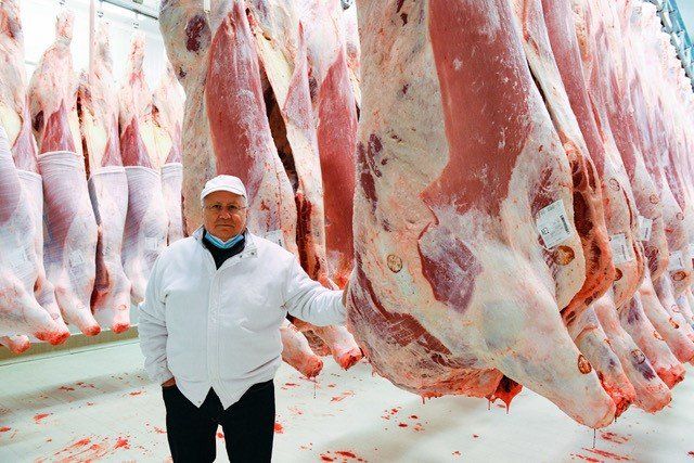 butcher with meat in a cold room