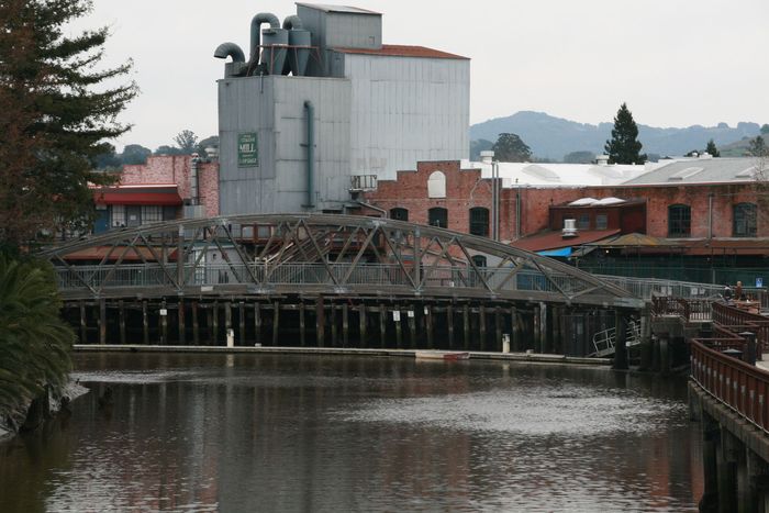 A bridge over a body of water with a building in the background