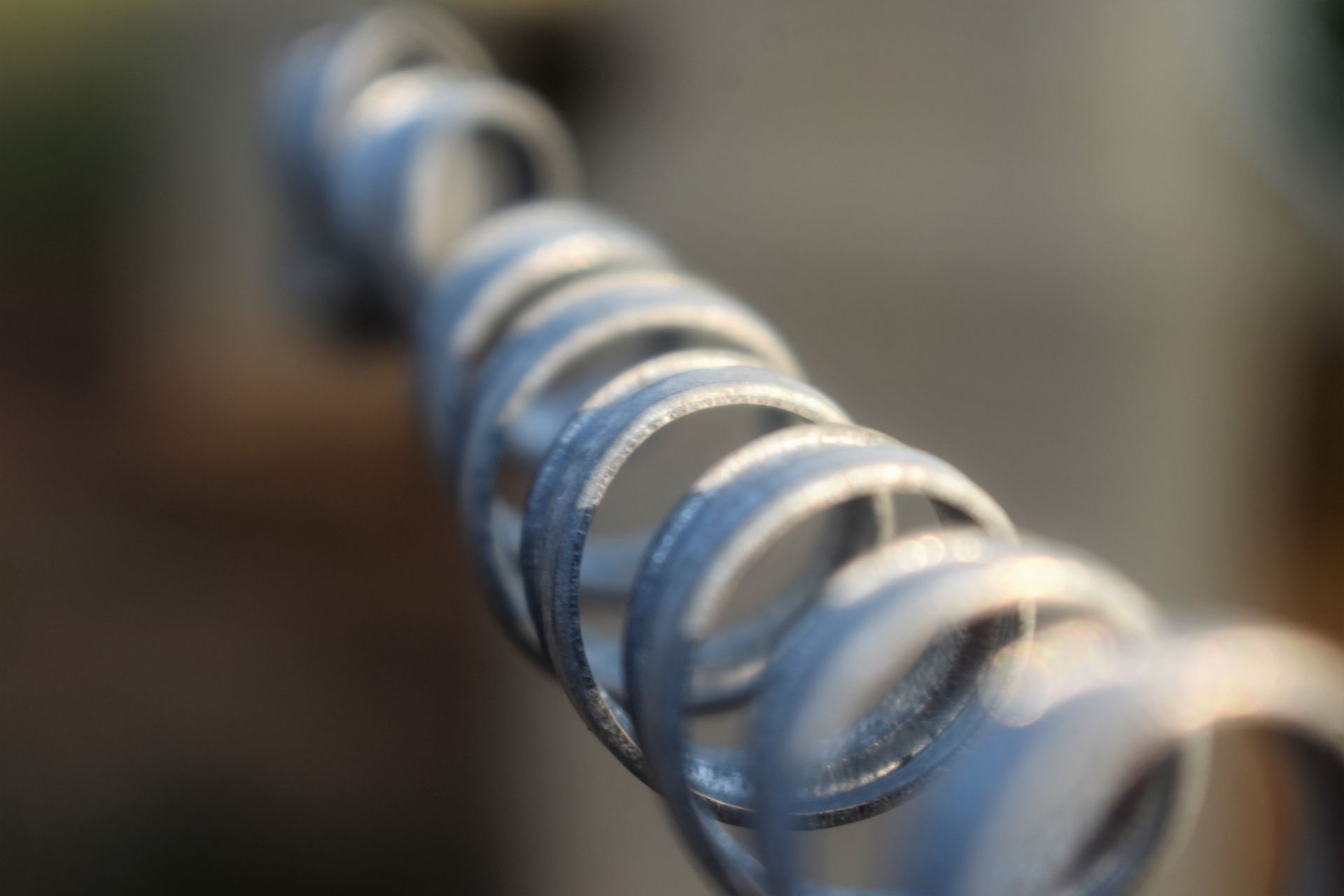 A close up of a metal spiral with a blurred background.