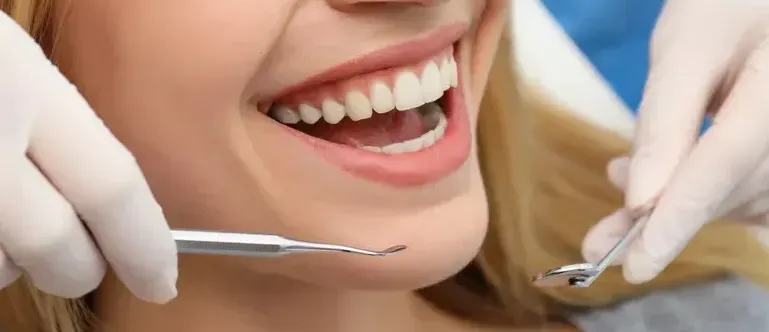 A woman is getting her teeth examined by a dentist.