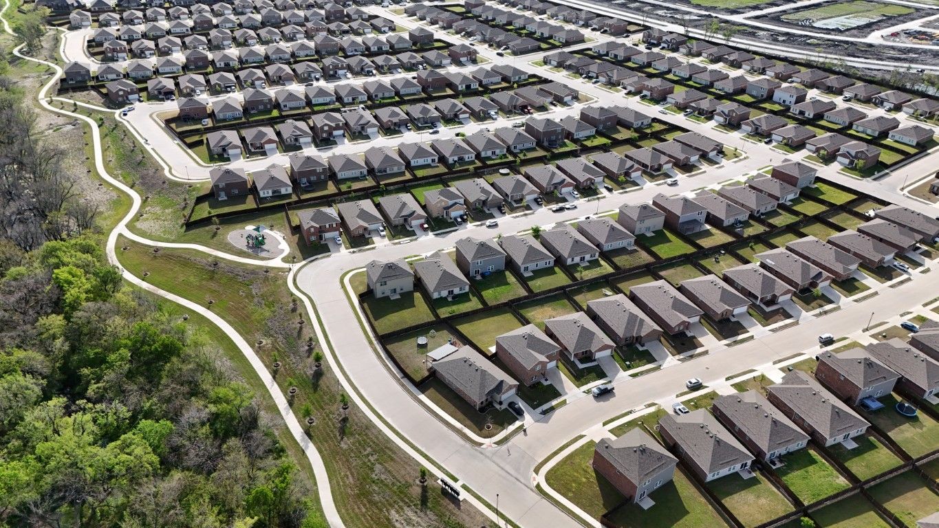An aerial view of a residential neighborhood with lots of houses and trees.