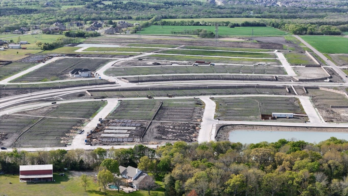An aerial view of a large residential area surrounded by trees and fields.