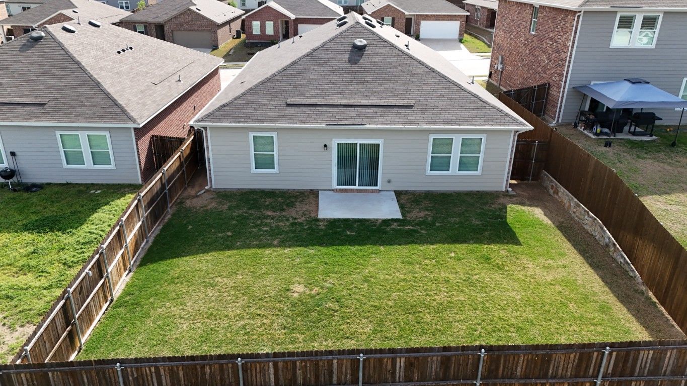 An aerial view of a house with a large lawn in front of it.
