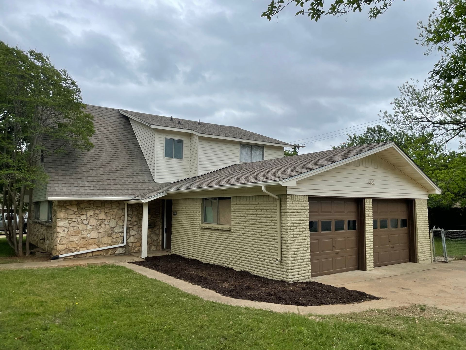 A large house with two garage doors and a roof.