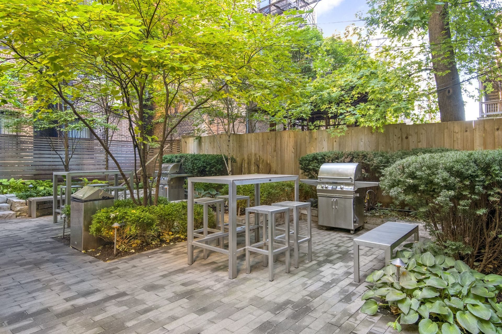 a small patio with tables and chairs and a grill