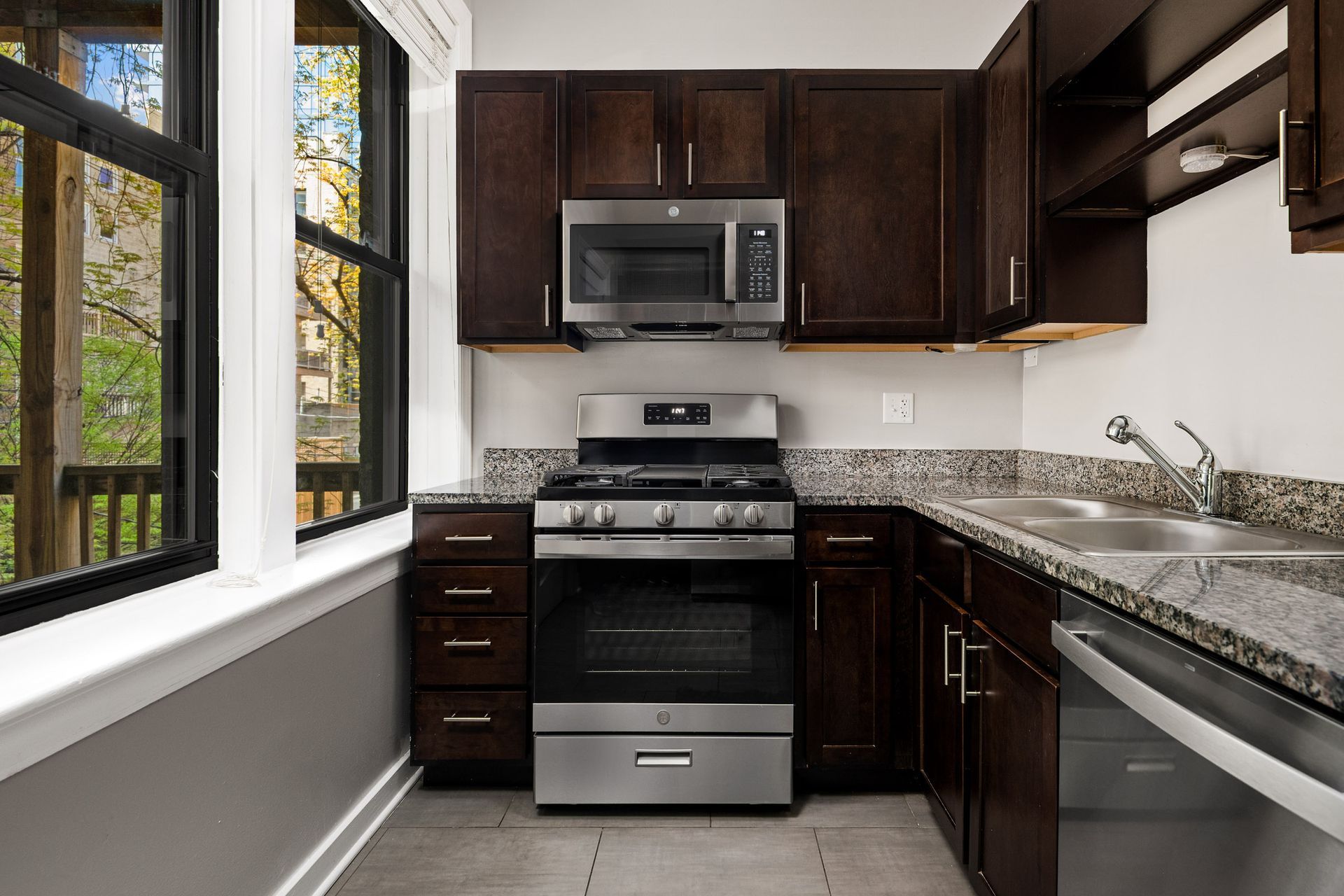 A kitchen with stainless steel appliances and granite counter tops at 429 W Melrose Street apartment.