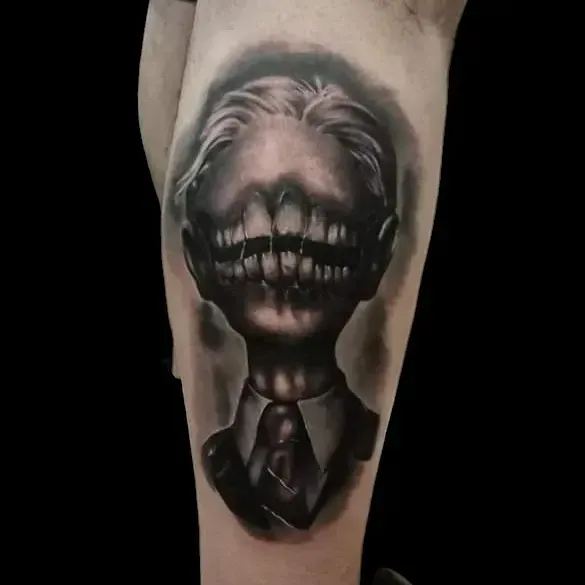 Tatuaggio di un uomo con grandi denti storti al posto del volto, vestito in giacca e cravatta. Bianco e nero.