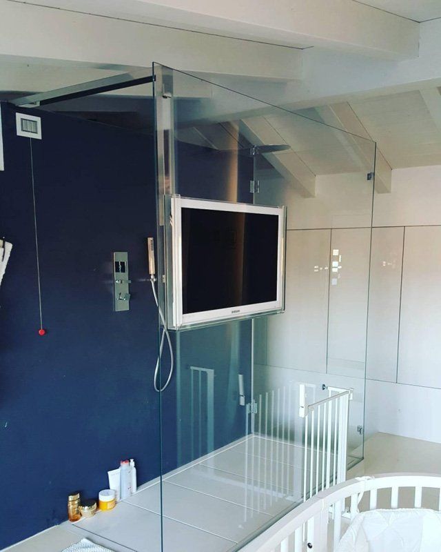 Bagno con televisore a muro su vetrata