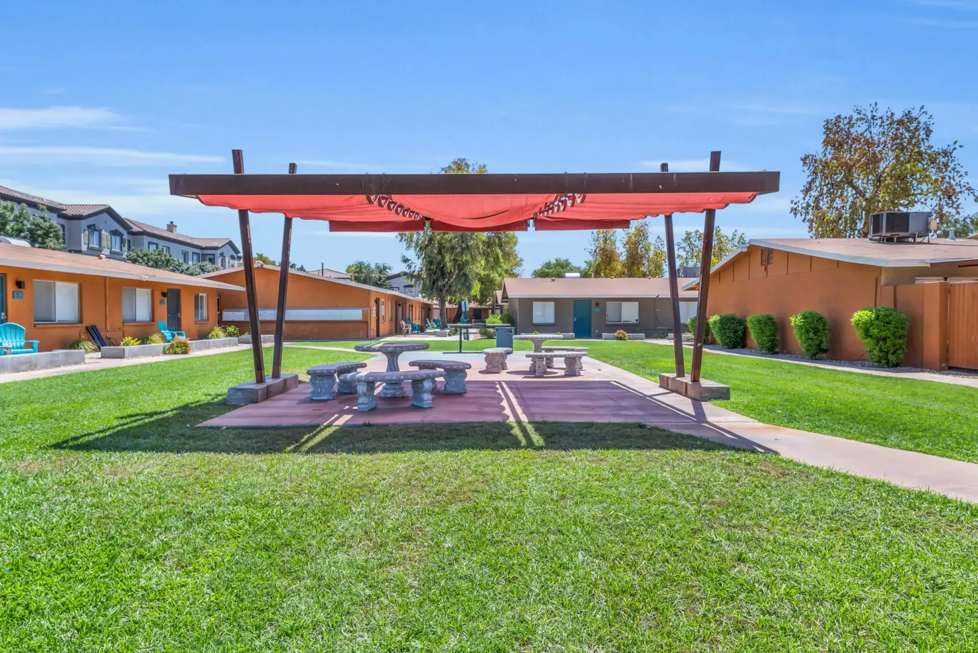 a picnic area with a red umbrella over it