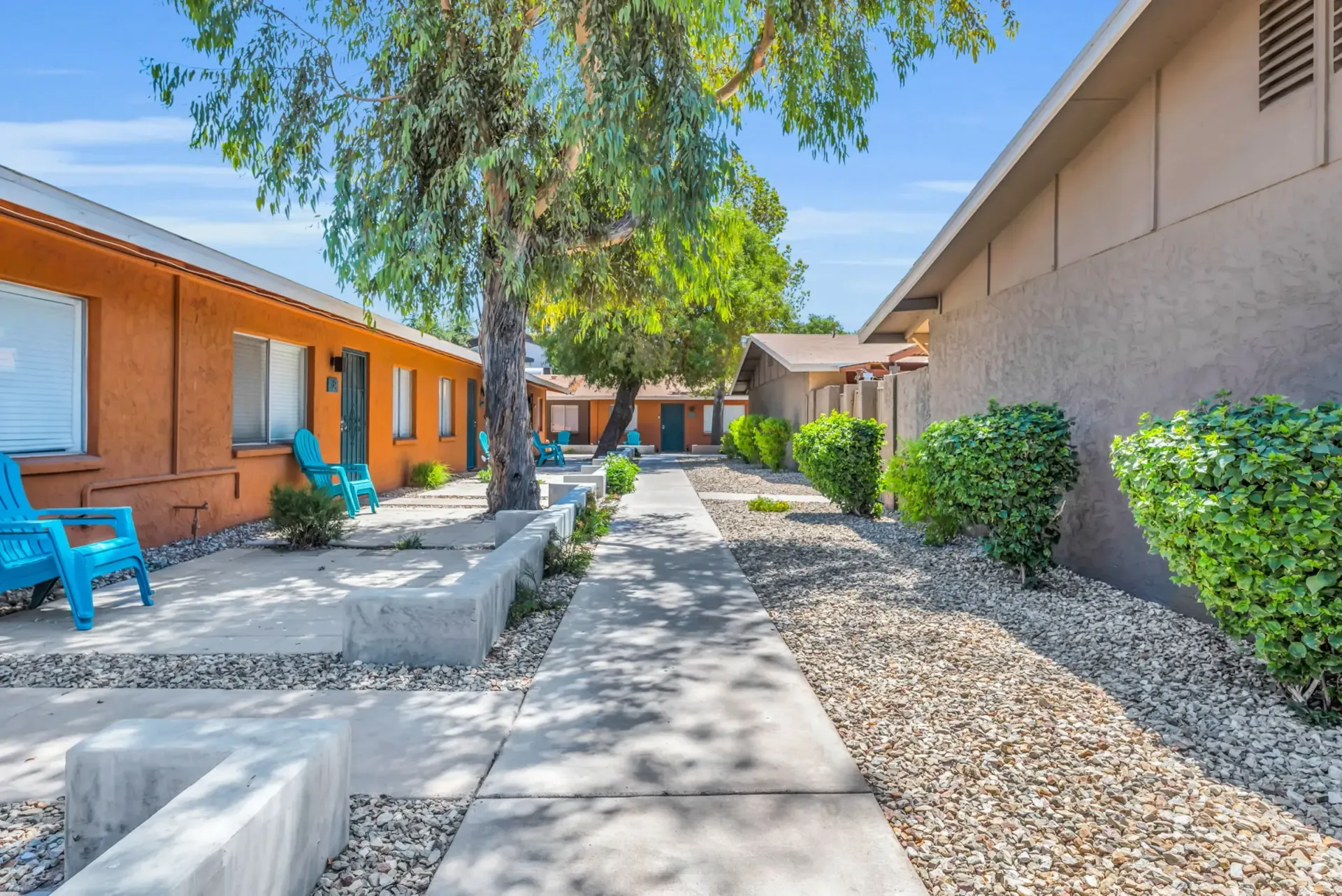 a row of buildings with blue chairs in front of them