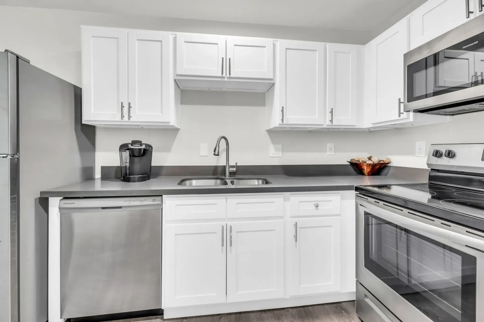 a kitchen with white cabinets and stainless steel appliances