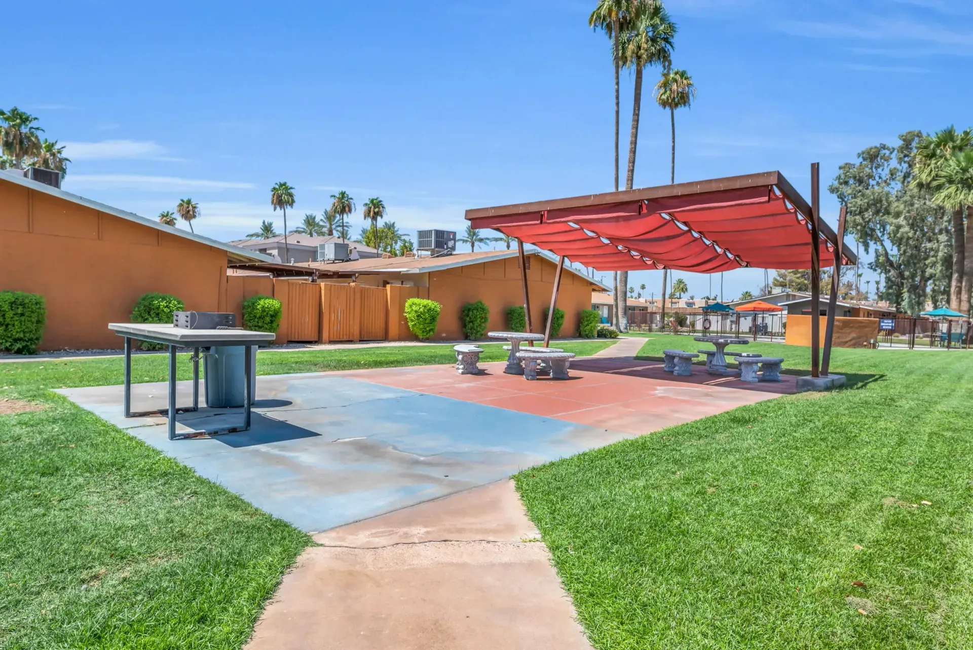a picnic area with a red umbrella over it