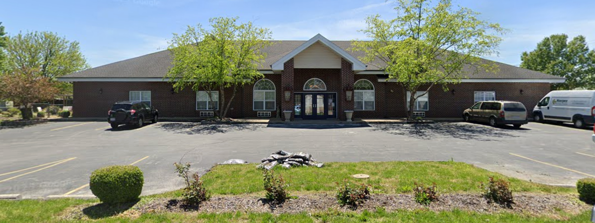A large brick building with a lot of cars parked in front of it.