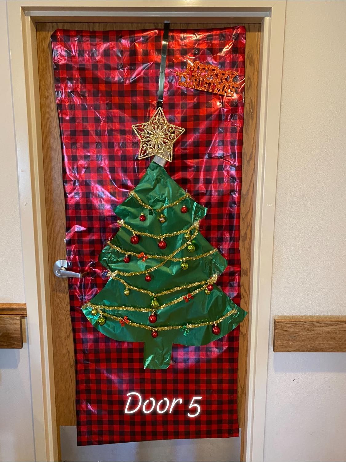 A door decorated for christmas with a christmas tree on it.