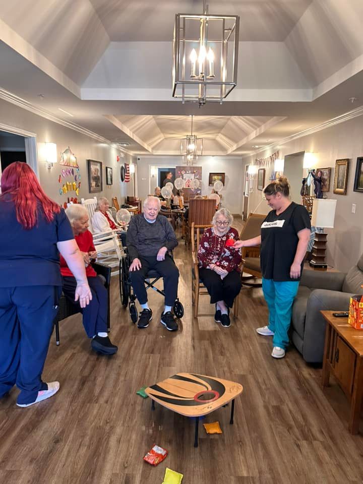 A group of elderly people are playing a game in a living room.