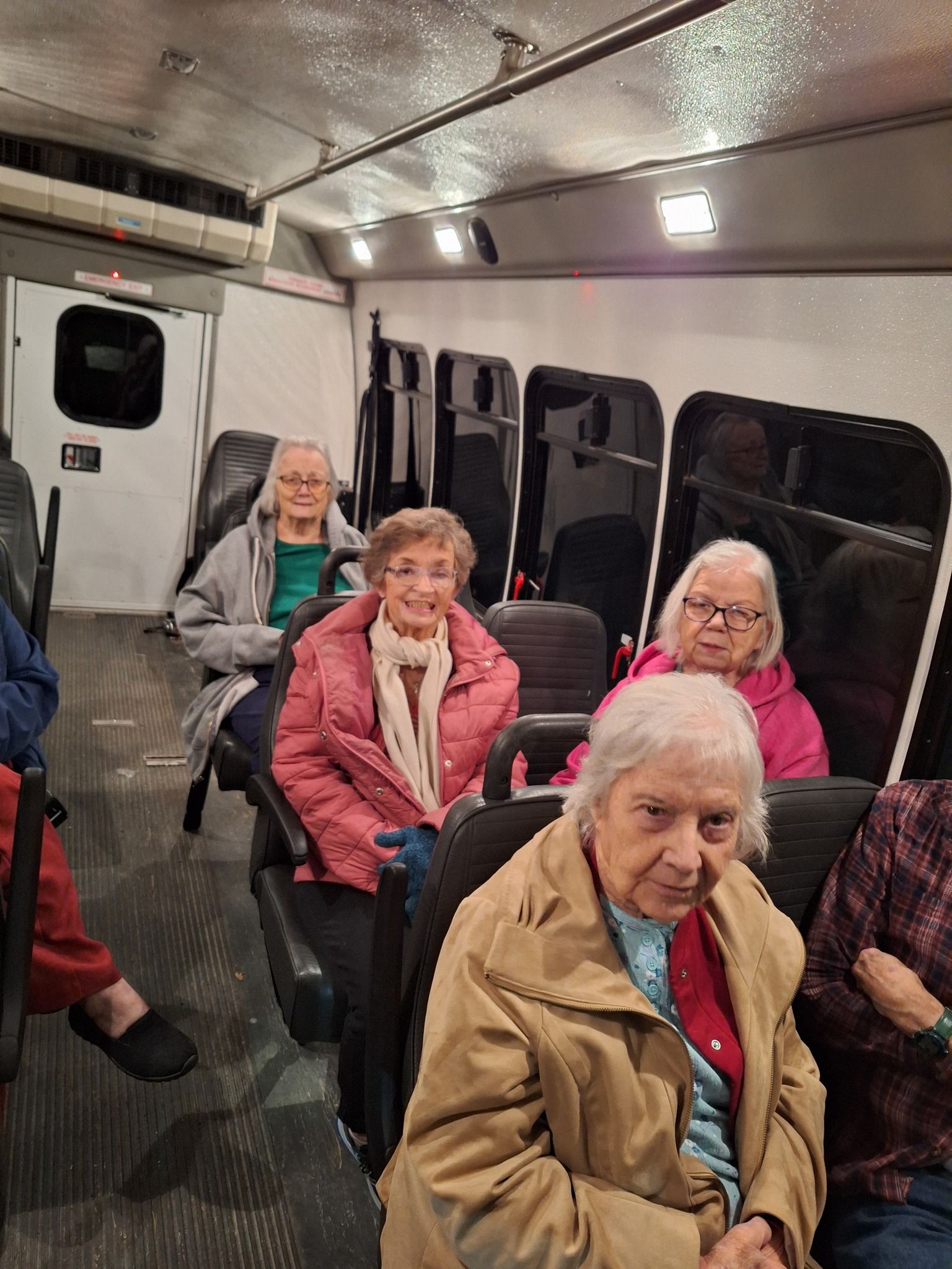 A group of older women are sitting on a bus.