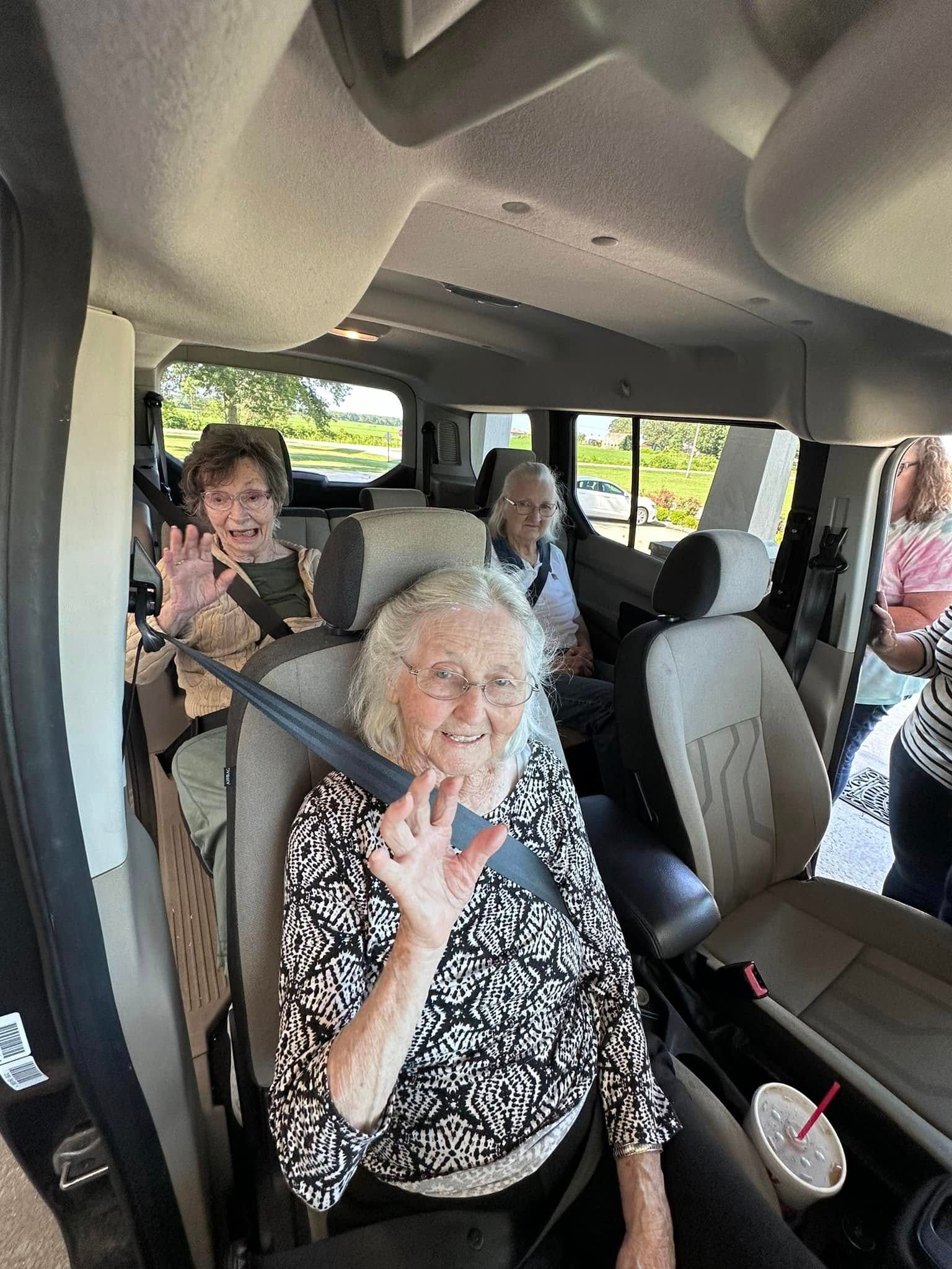 A group of people are sitting in the back seat of a car.