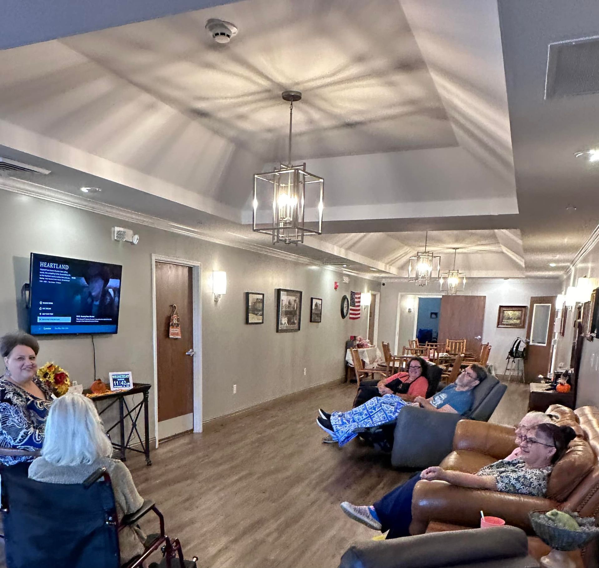 A group of people are sitting in chairs in a living room