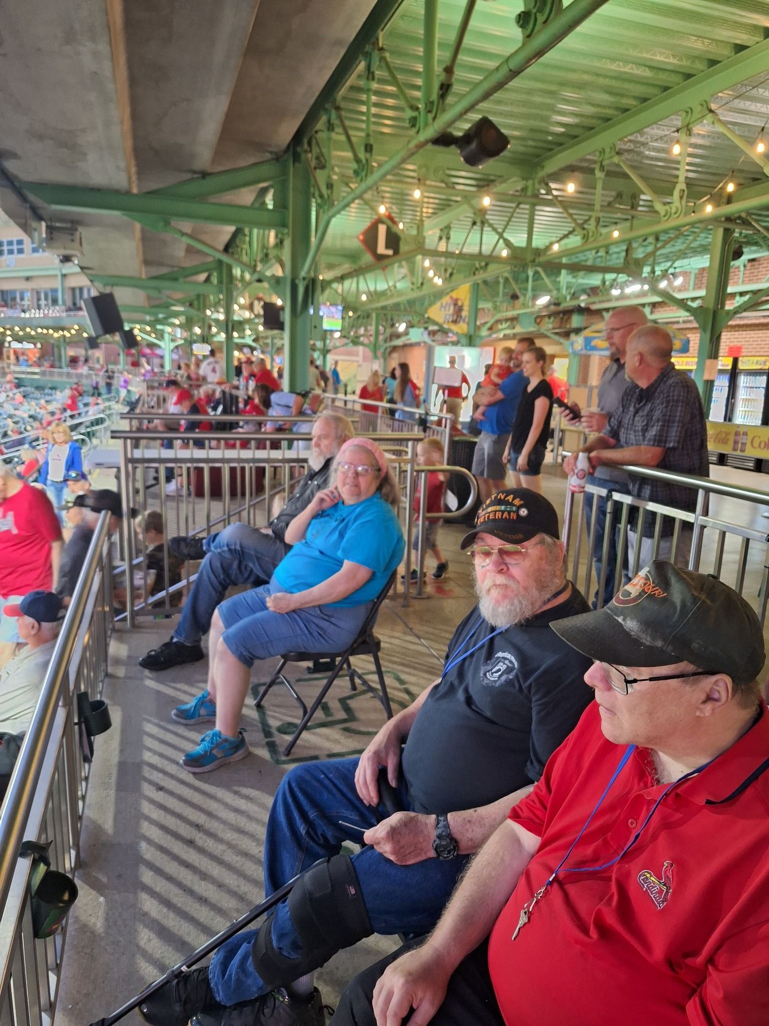 A group of men are sitting in a stadium watching a baseball game.