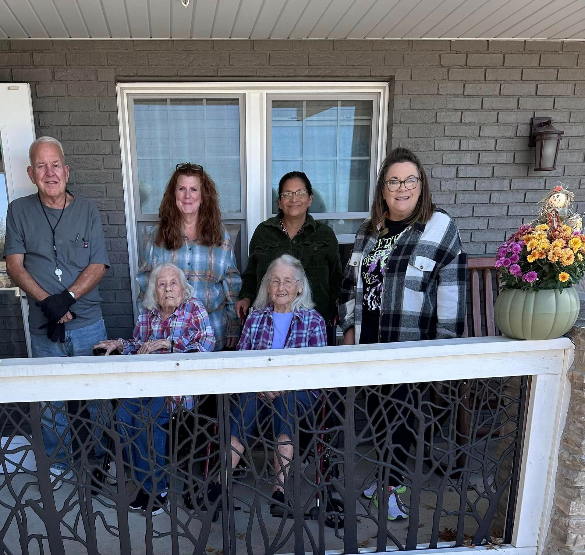 A group of people are posing for a picture on a porch