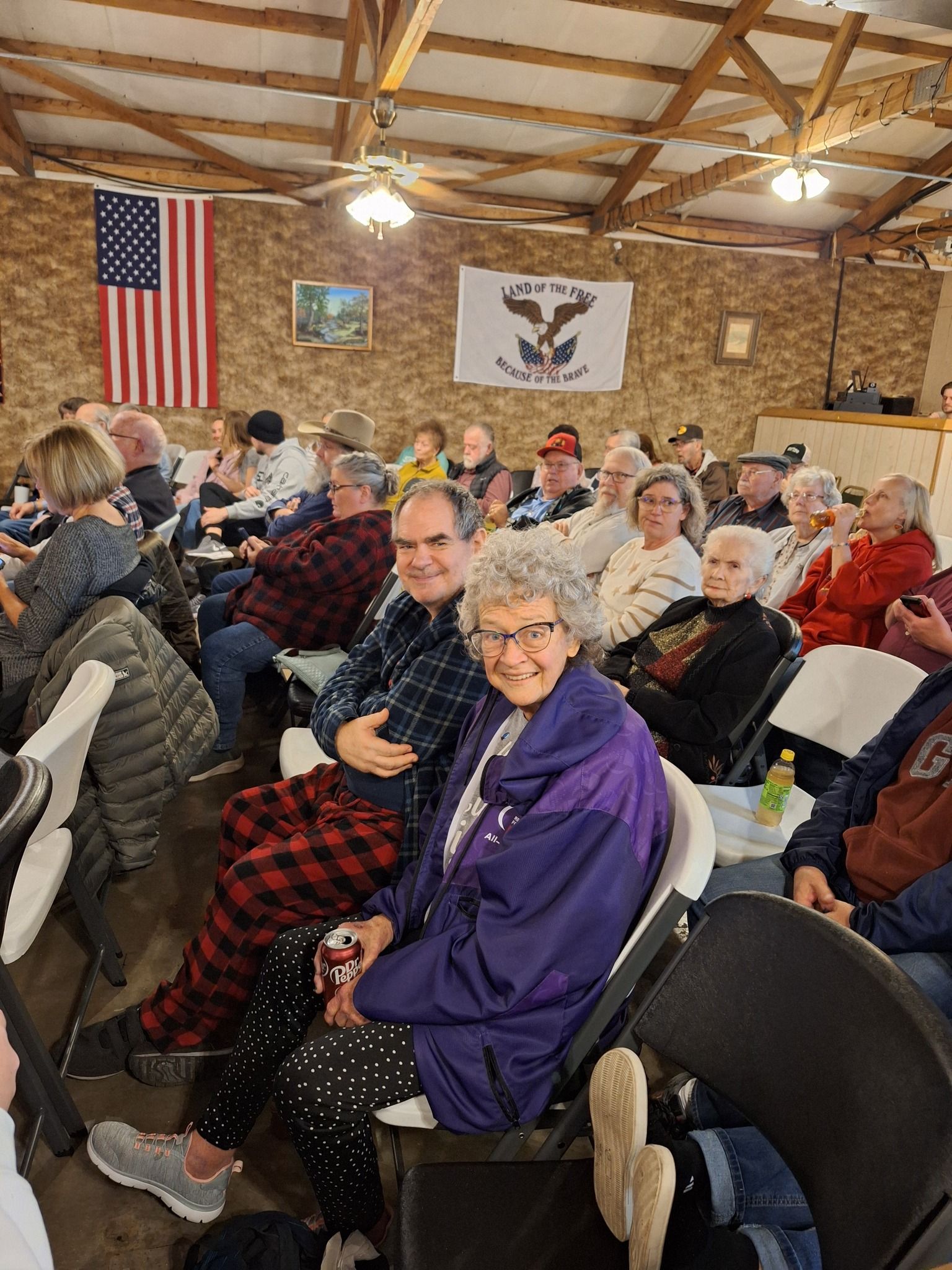A large group of people are sitting in chairs in a room.