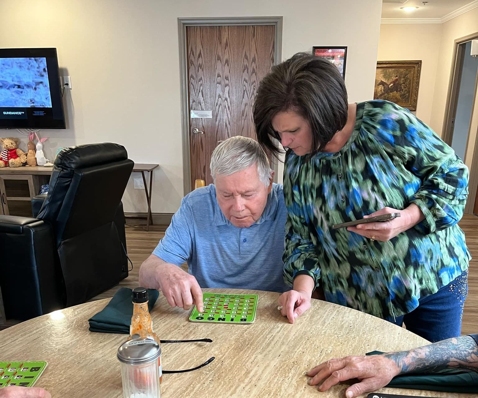 A man and a woman are sitting at a table playing bingo.