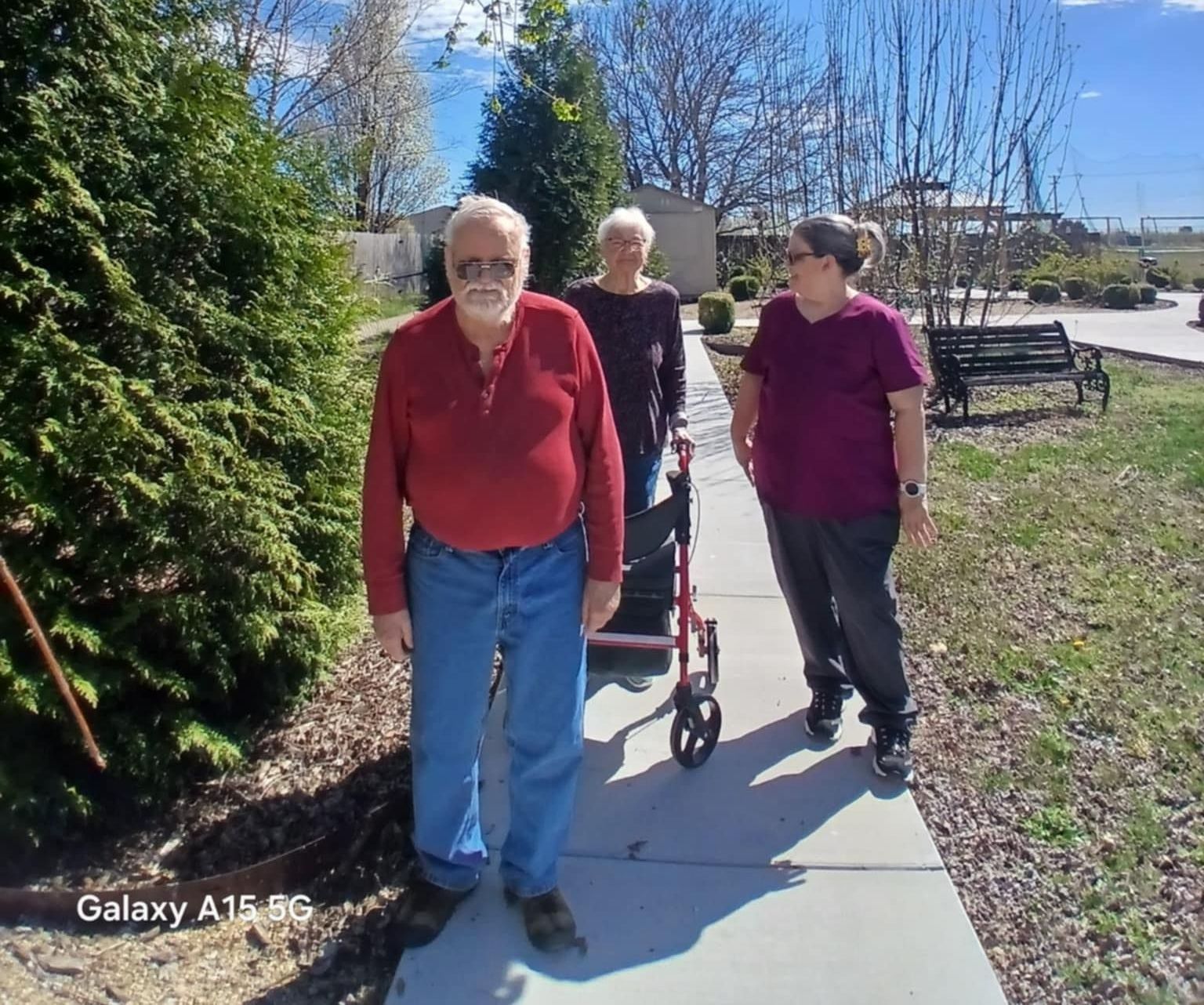A group of people walking down a sidewalk with a galaxy a15 pg in the background