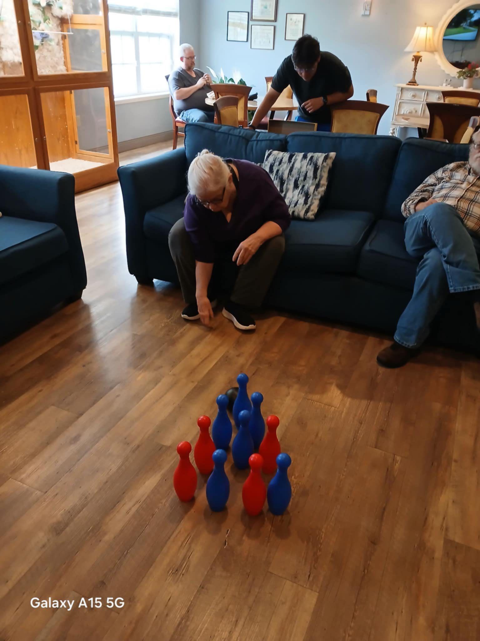 A group of people are playing bowling in a living room.