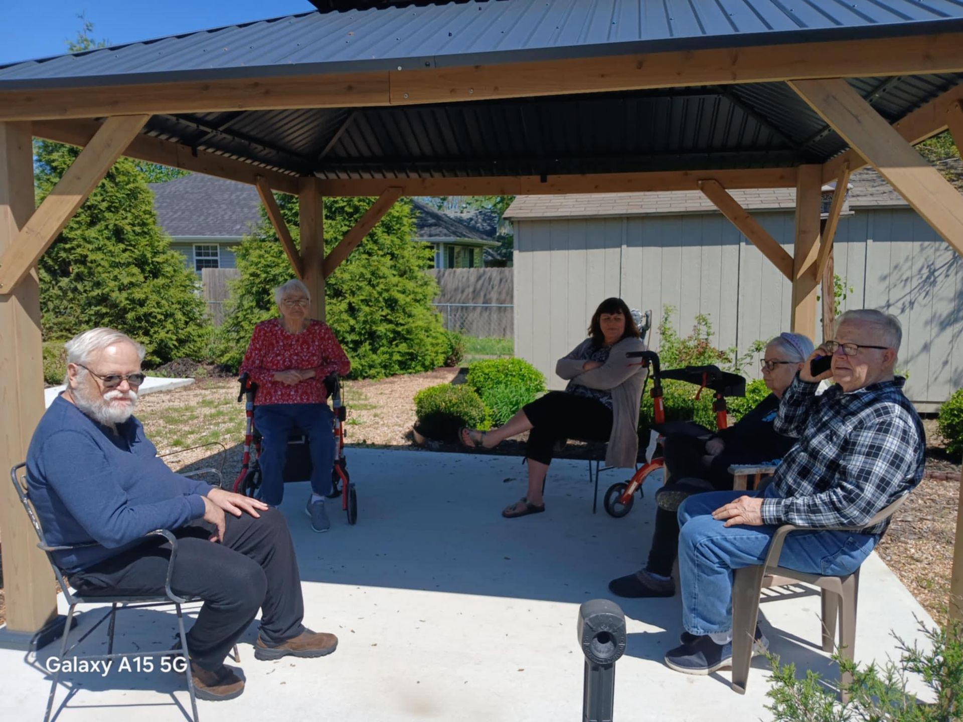 A group of people are sitting under a gazebo.