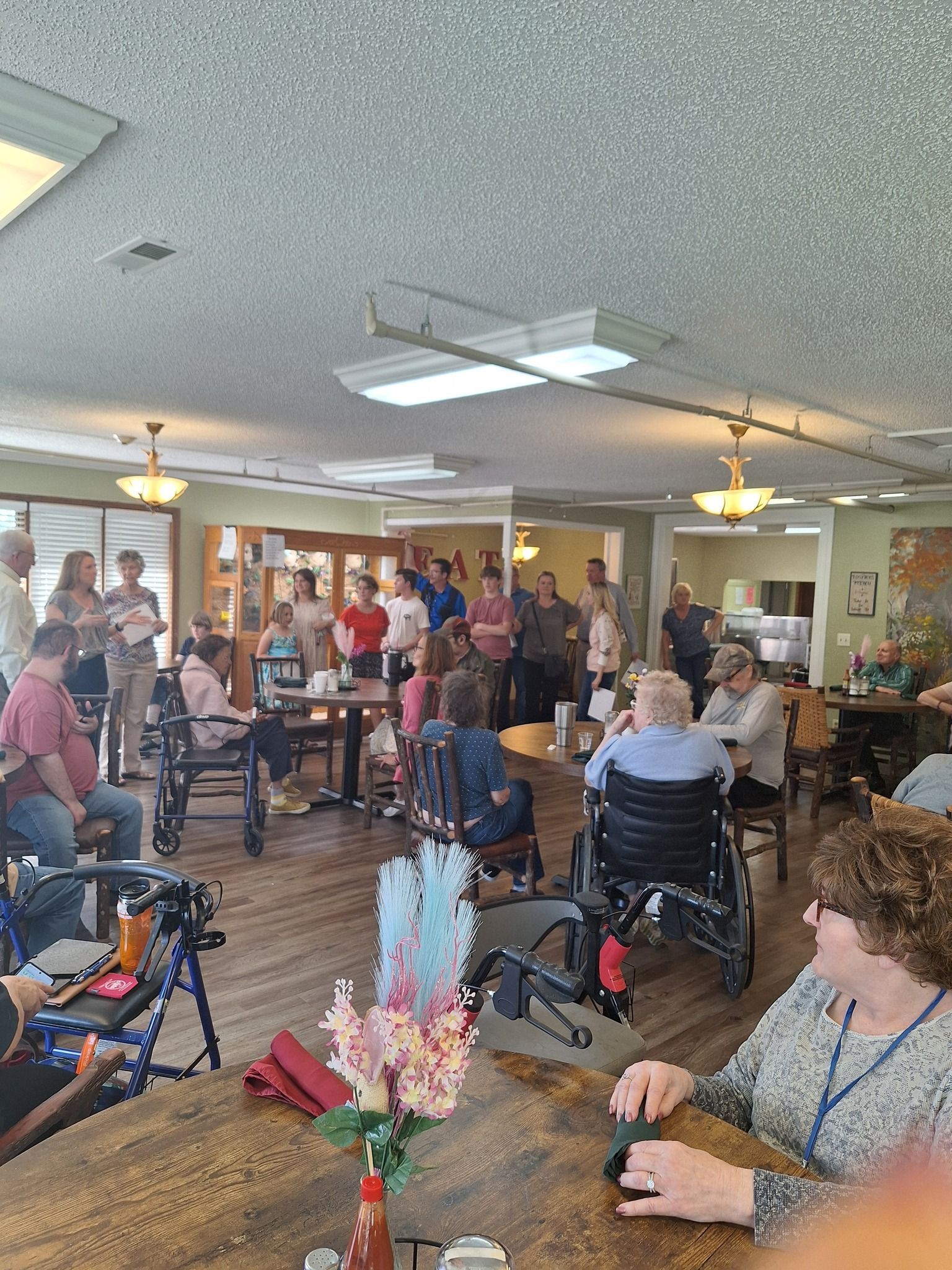 A large room filled with people sitting at tables and chairs.
