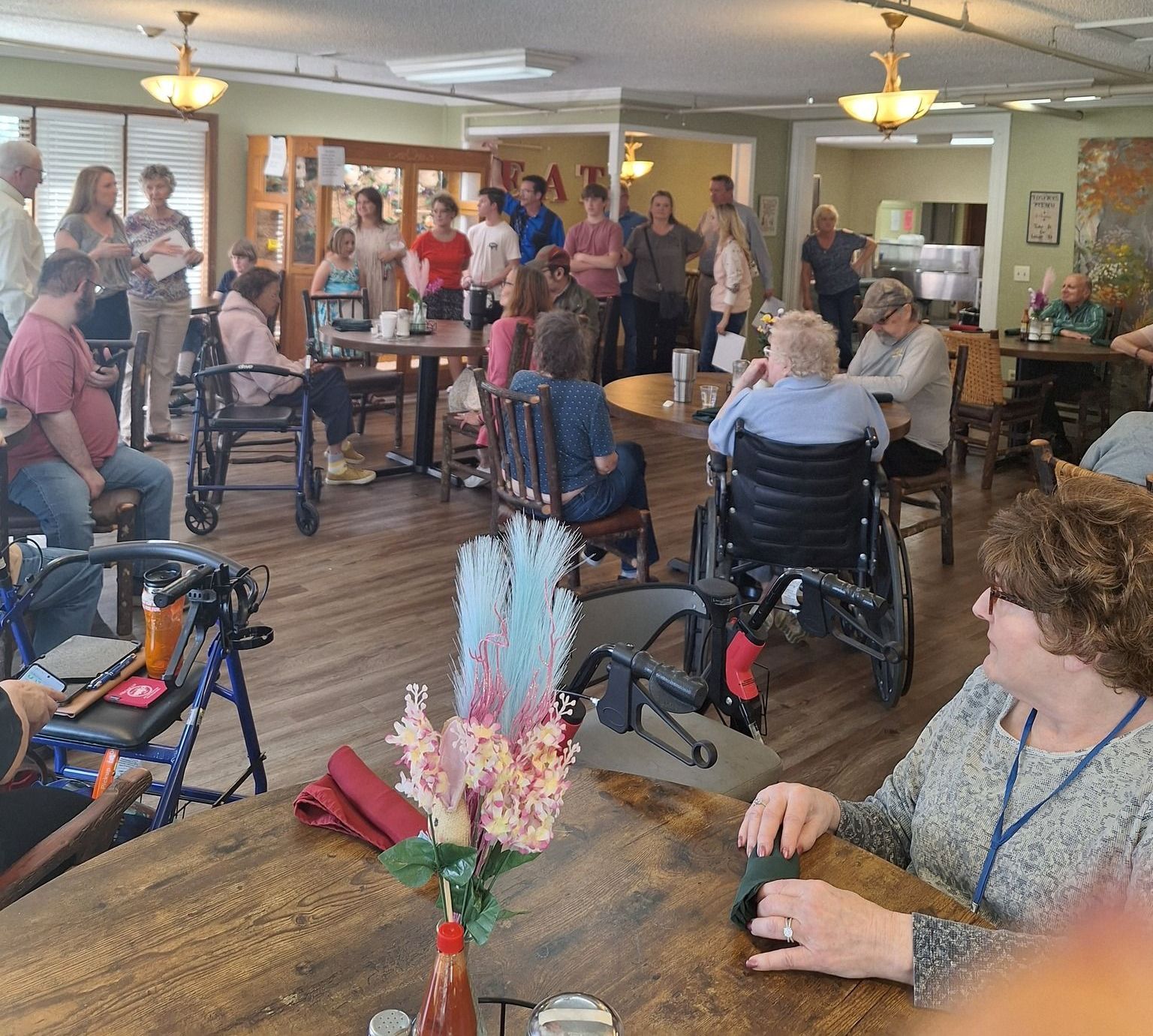 A woman in a wheelchair sits at a table with other people