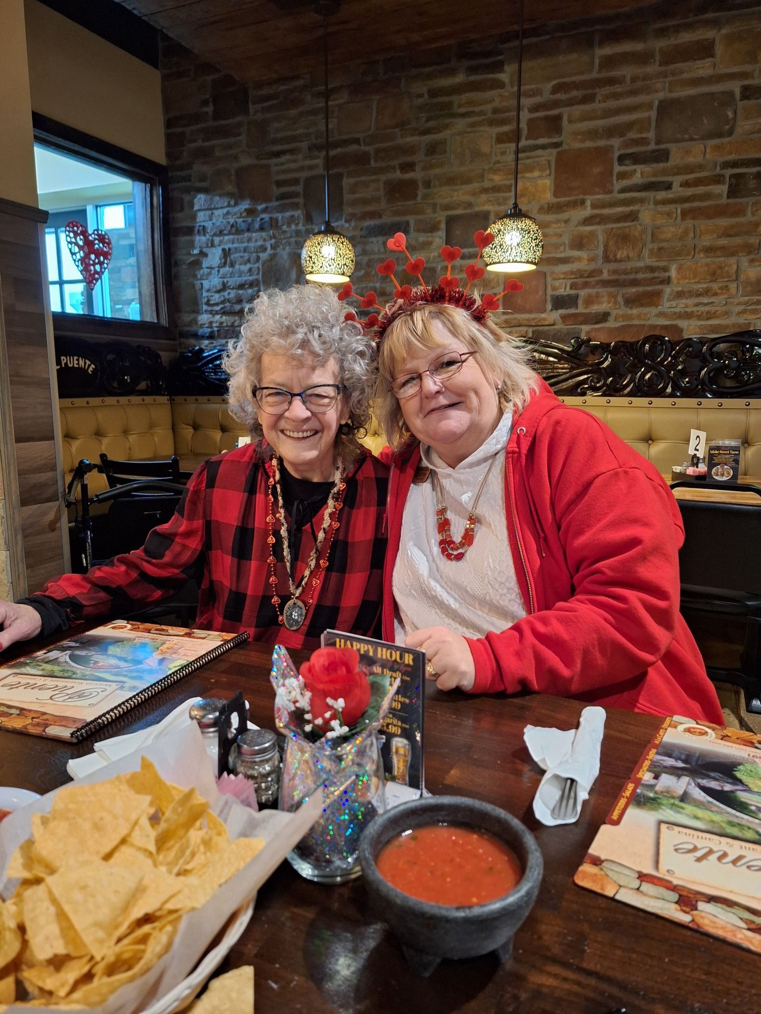 Two older women are sitting at a table in a restaurant.