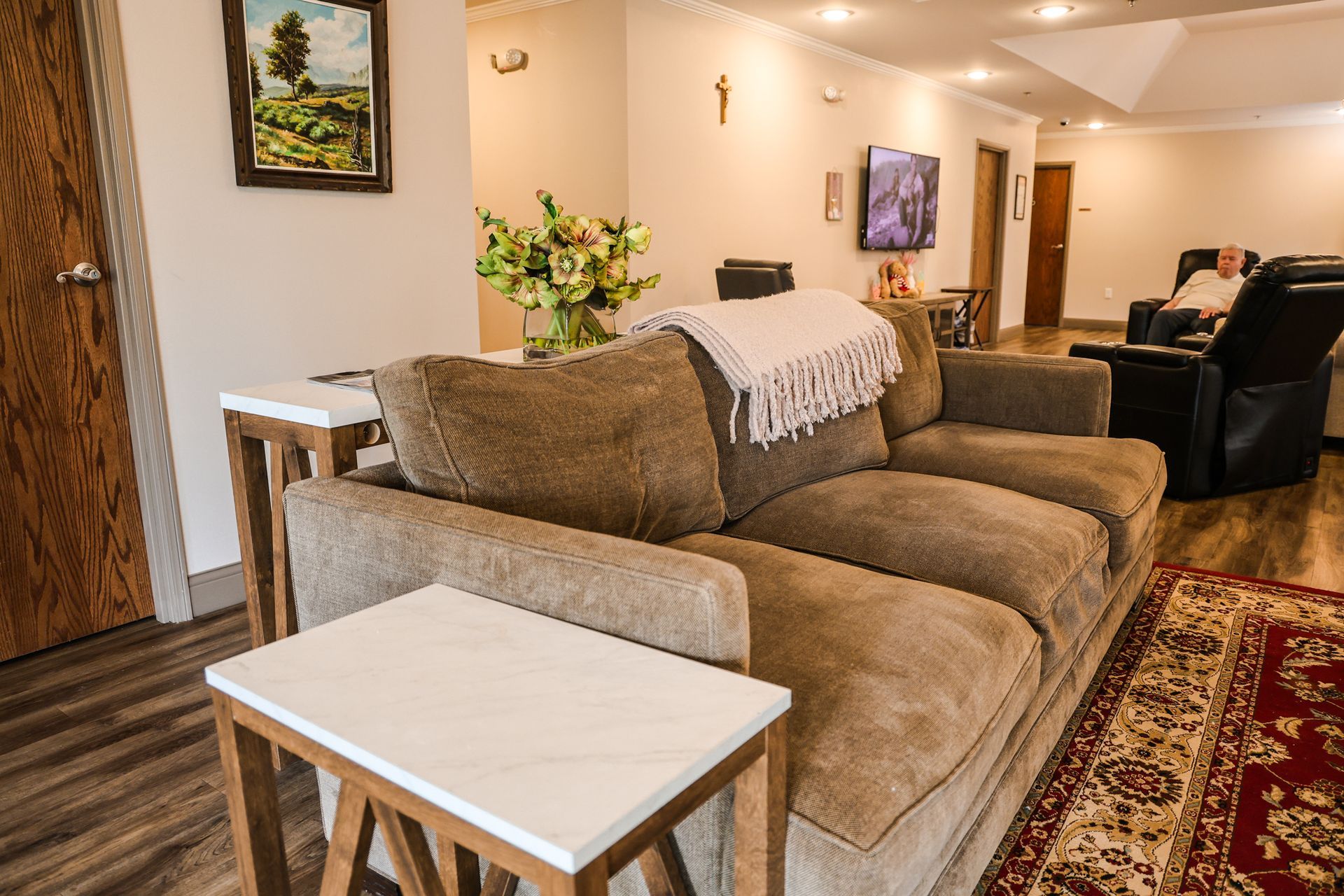 A living room with a couch , chairs , and a table.