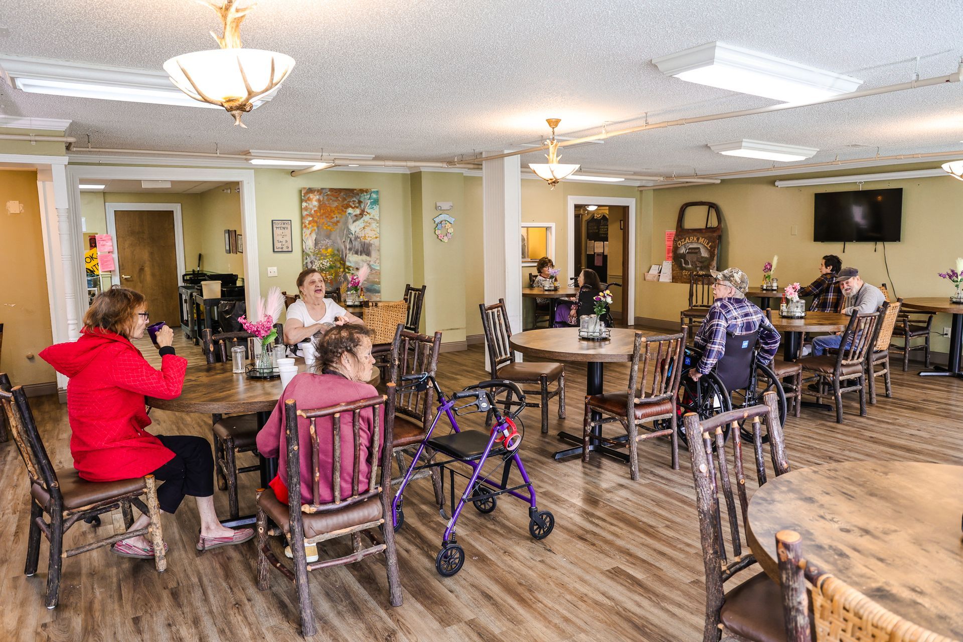A group of people are sitting at tables in a dining room.