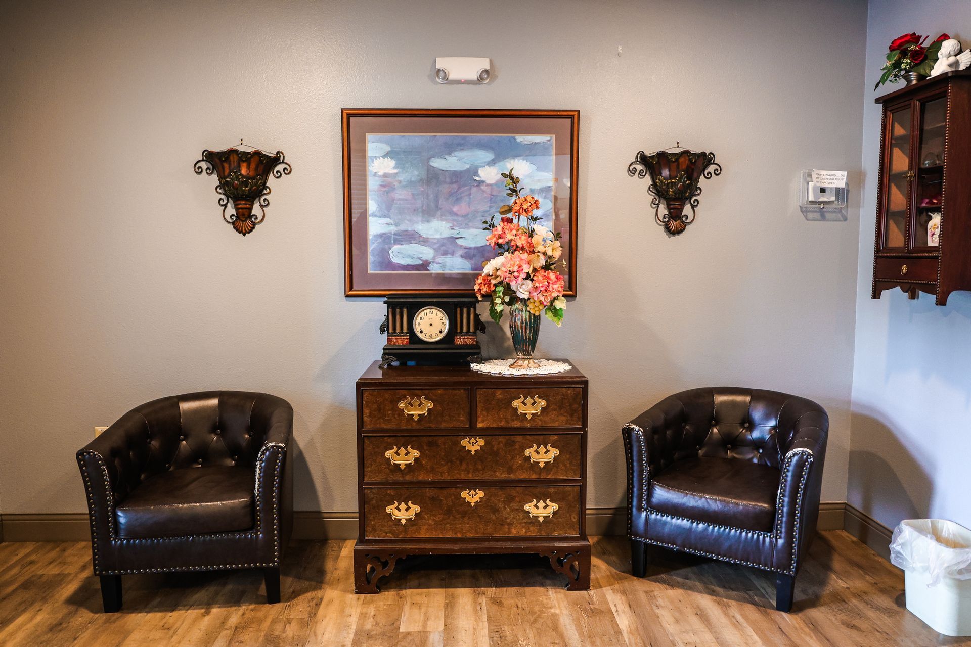 There are two chairs and a dresser in the room.