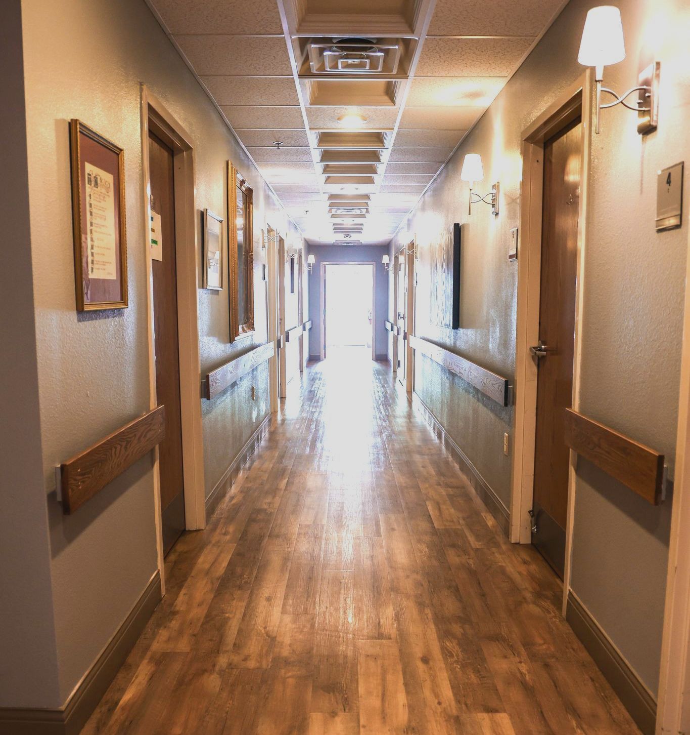 A long hallway with wooden floors and doors
